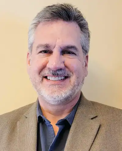 Photo of Randall Schrock smiling and wearing a suit